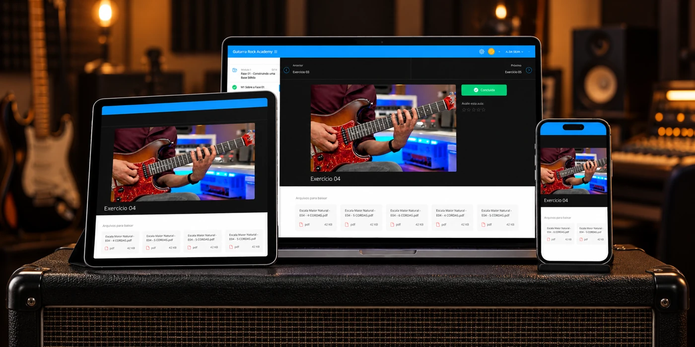 Guitarra Rock Academy em notebook, tablet e celular sobre um amplificador, com um estúdio desfocado ao fundo